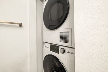 A white washing machine is installed in a wall.